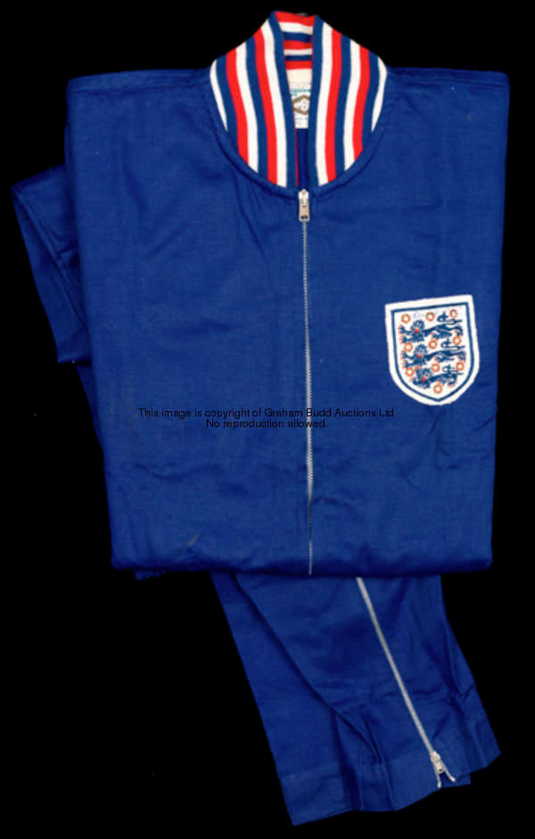 A signed Bobby Moore England training suit, signed by Bobby Moore on the three lions badge, a blue U...