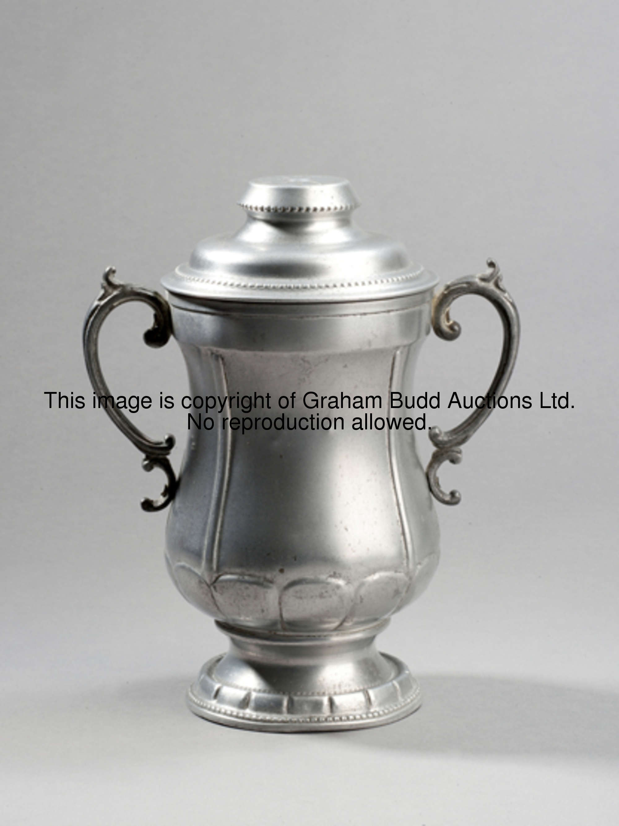 A Huntley and Palmers F.A. Cup trophy biscuit tin 1927, in aluminium, height 21cm., 8 1/4in.  These ...