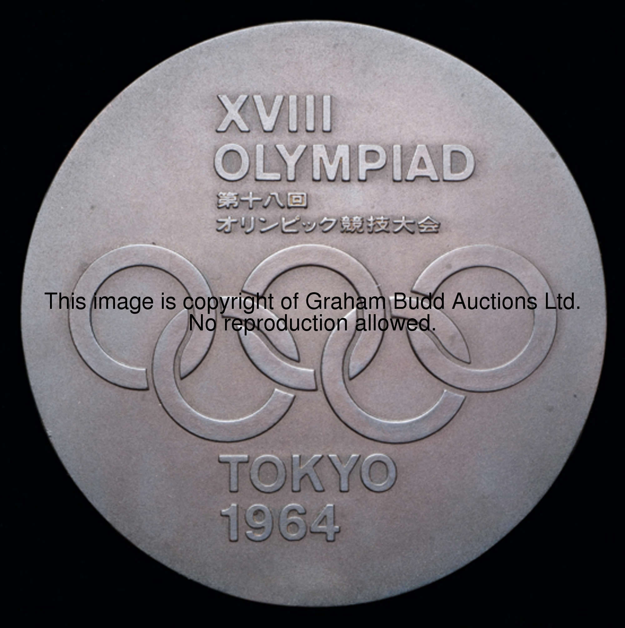 A 1964 Tokyo Olympic Games participation medal, designed by T. Okamoto and K. Tanaka, stylised three...