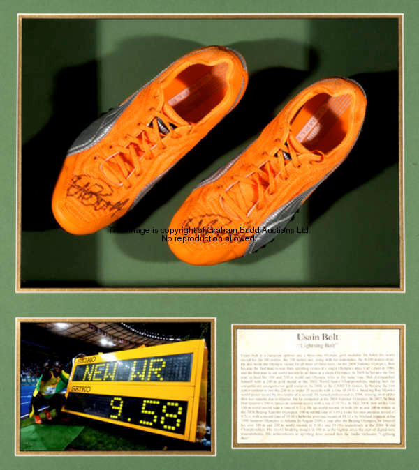 An autographed Usain Bolt track shoes display, A pair of Orange Puma track shoes both signed by Bolt...