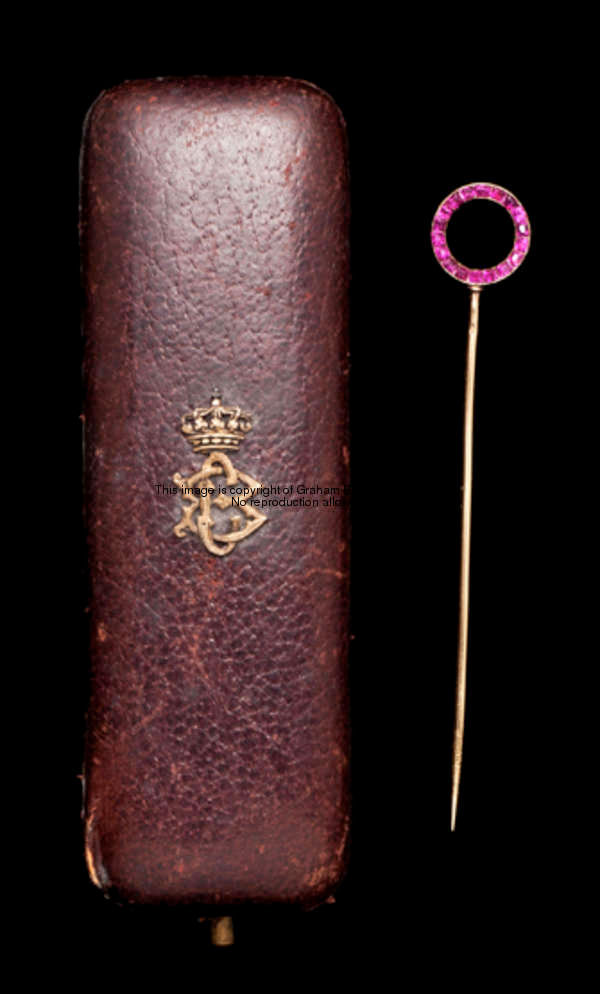 A reversible gold stick pin set with rubies to one side and diamonds to the other designed as a winn...