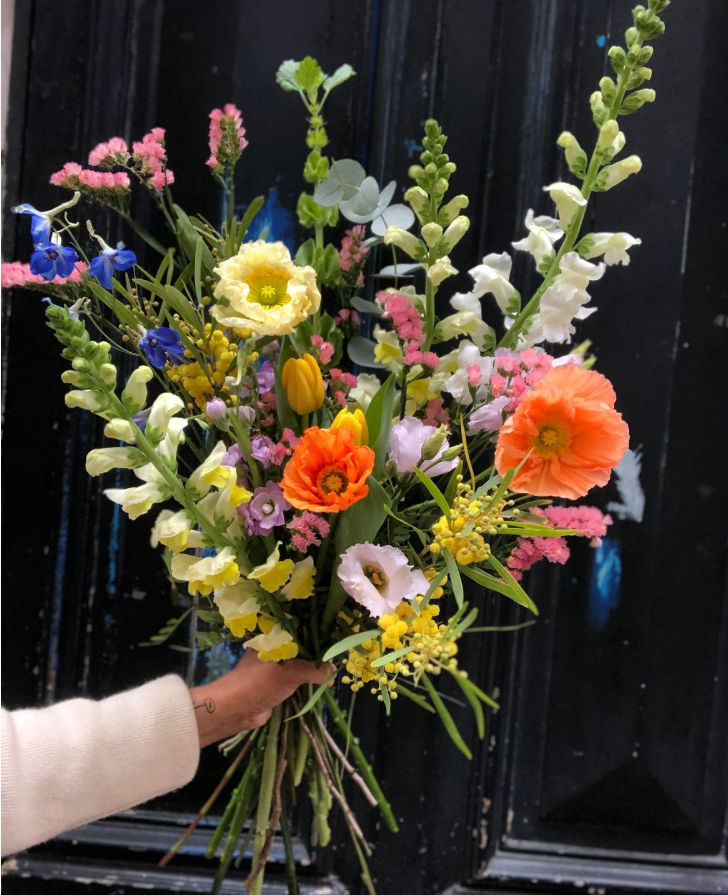 Gros plan sur une arche de fleurs de mariage dans des tons roses et blancs.