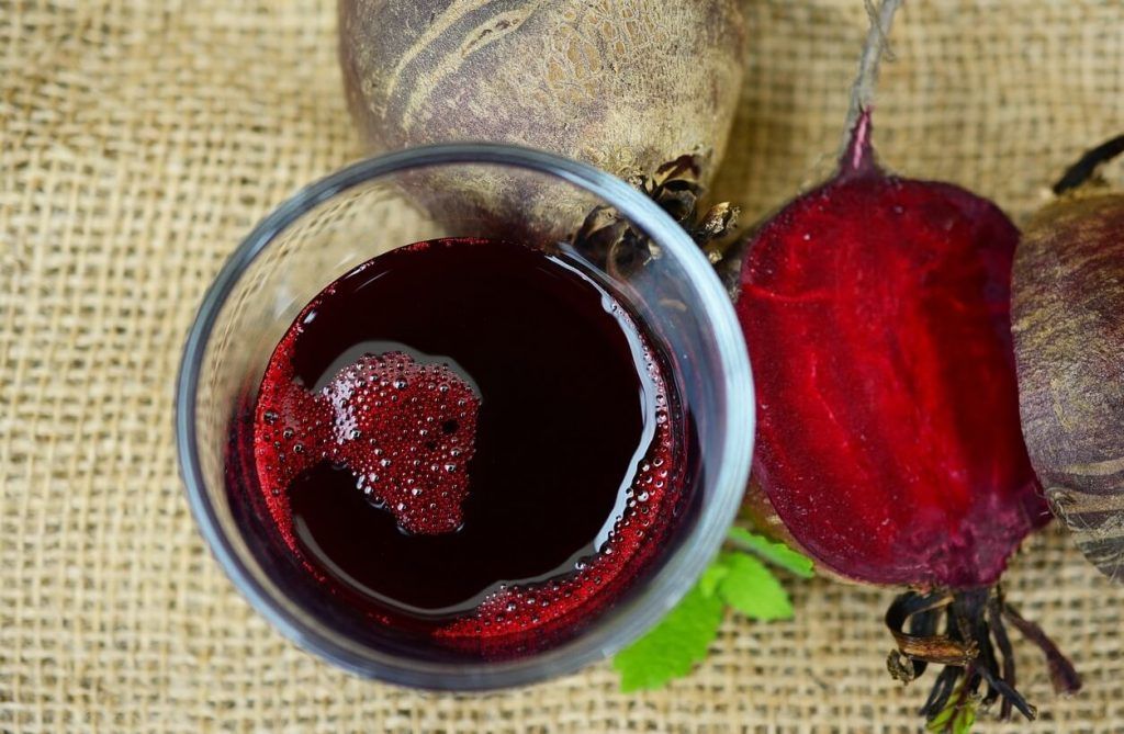 Glass of beet juice and raw beets