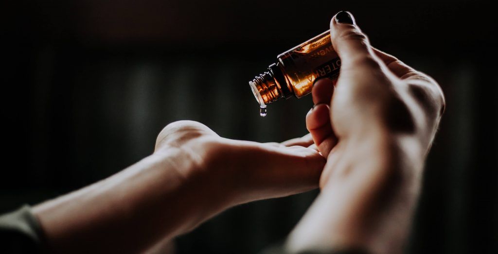 Applying serum in glass bottle to hand