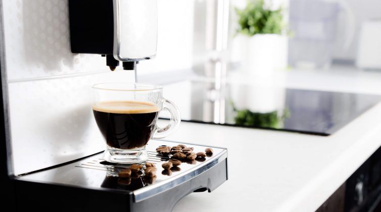 White home espresso machine with cup and coffee beans