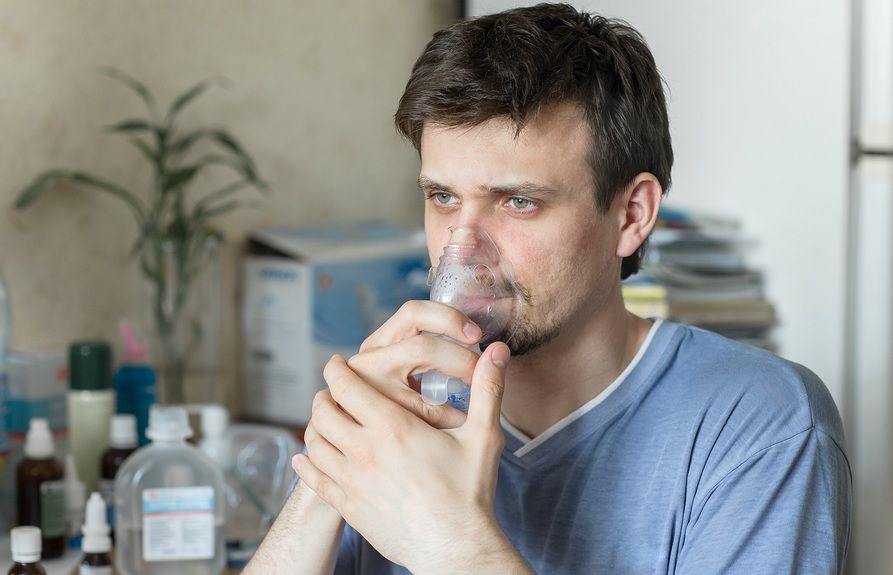 Young male with cystic fibrosis uses breathing apparatus