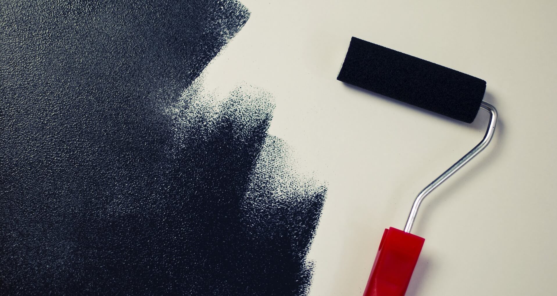 Black paint roller on white wall