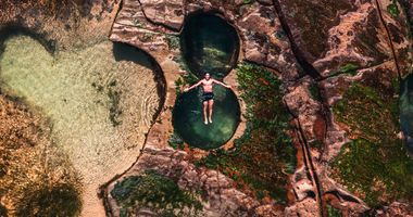 Aerial photograph, person floating in the water at the figure 8 pool in Sydney