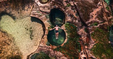 Aerial photograph, person floating in the water at the figure 8 pool in Sydney