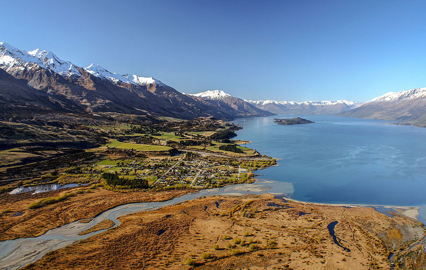 aerial view of lakeside town with mountains in the background