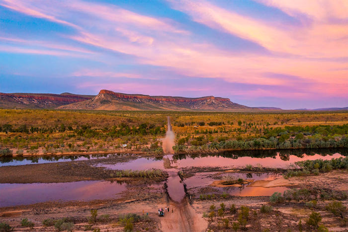 Campervan flooded river crossing in a vast outback landscape