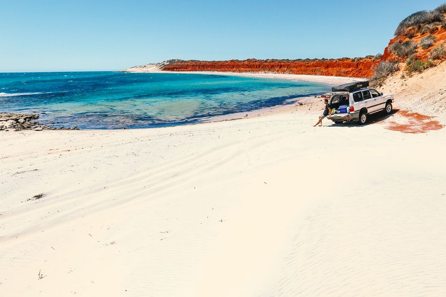 4WD camper on the beach with turqoise water and white sand