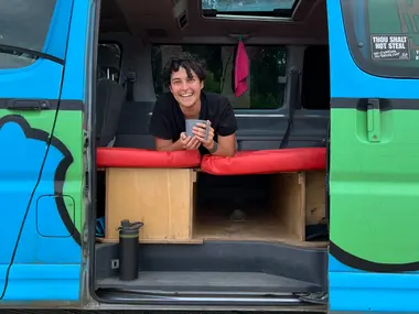Relaxing with a mug inside the Mystery Machine camper
