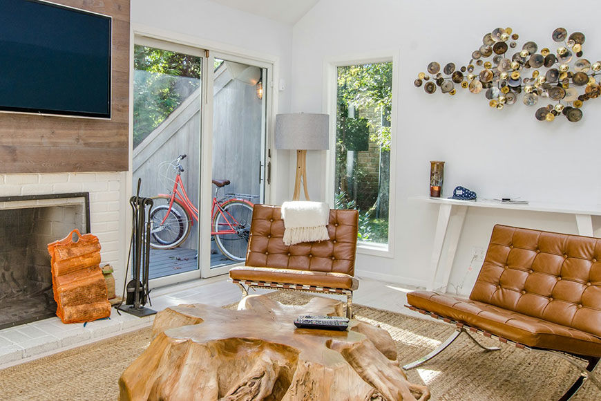 Schickes Wohnzimmer mit Fernseher an einer Holzwand und zwei Ledersesseln