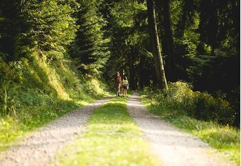 Zwei Mädchen laufen auf einem Weg durch den Schwarzwald