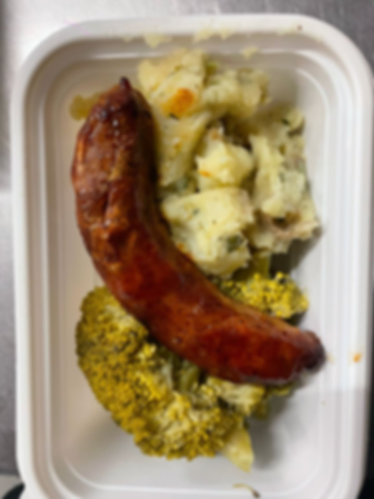 Salchicha de la casa acompañada de puré de papas estilo criollo y broccoli al vapor