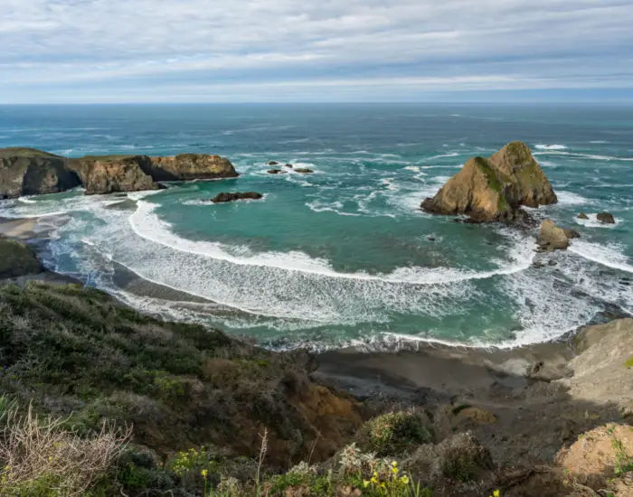 Northern California coastline along Pacific coast highway with waves approaching the shore.