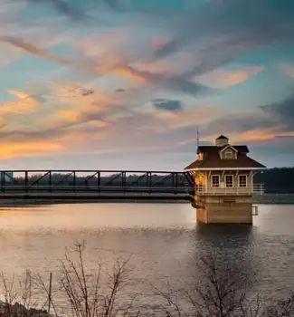 Building in a lake in front of a bridge during sundown in the Newark Reservoir, Utah.