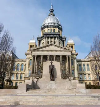 Abraham Lincoln statue standing proud in front of the Illinois State Capital Building in Springfield. on a sunny day in fall or winter.