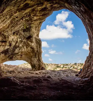 Inside looking out view from Marengo Cave in Indiana with a clear blue sky.