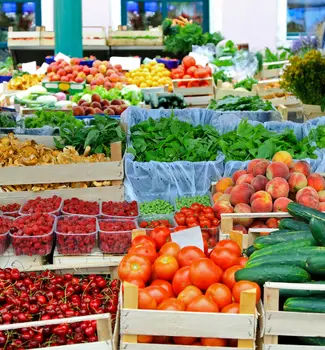 Fruit and vegetable produce arranged in crates and boxes on a table in Downtown Farmer's Market in Iowa.