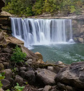 Cumberland falls in Corbin Kentucky with water flowing between nature with trees and rocks.