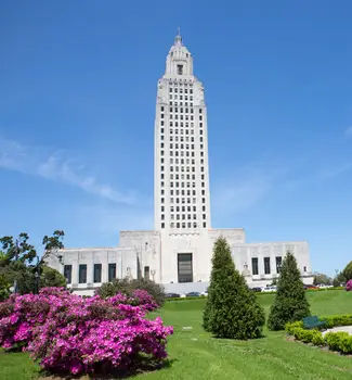 Louisiana State Capital Building in Baton Rouge surrounded by a large field of grass and flowers.