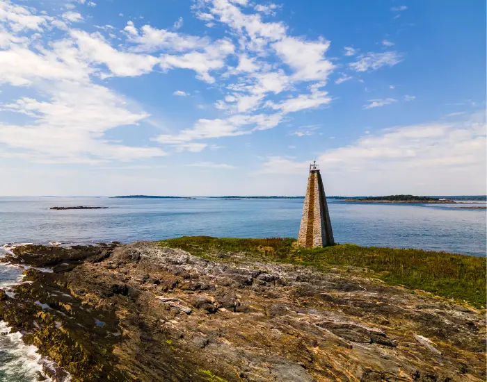 Main island lighthouse on the coat of the ocean on a sunny day.