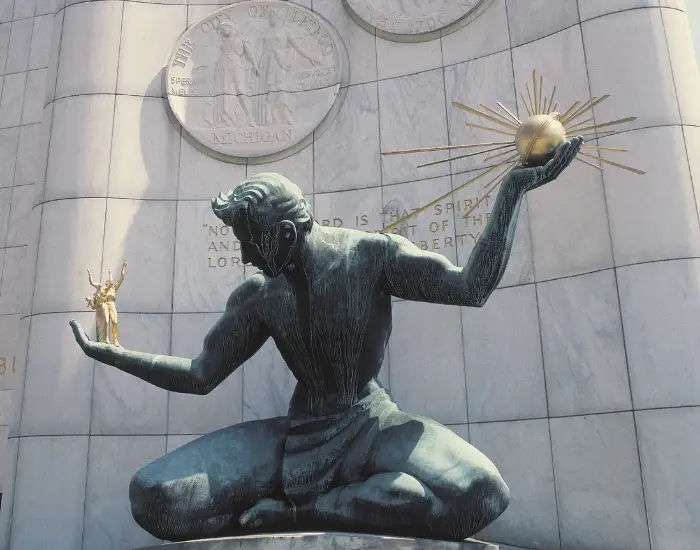 Spirit of Detroit sculpture in Detroit, Michigan of a man holding a golden ball in one hand and people in another.