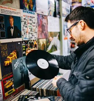 Male travel nurse looking at a record in Motown Records, Michigan.