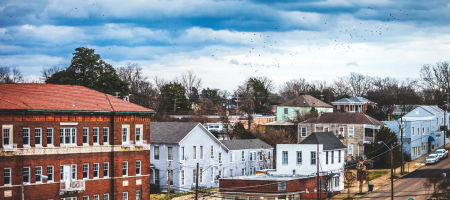 Small town of Vicksburg, Mississippi in winter with historically ages buildings and birds flying around in the sky.