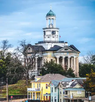 Old court house in Vicksburg, Mississippi wit streets lined with wooden houses.