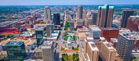 Aerial view of St. Louis, Missouri during the day overlooking buildings, streets, cars, and the stadium.