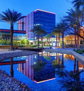 Summerlin in Southern Nevada with buildings reflecting off a fountain at night.