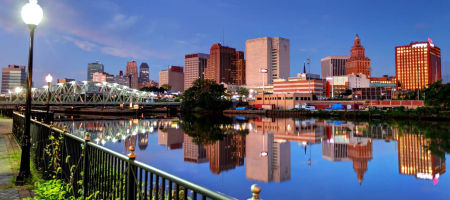 Newark, New Jersey waterfront from a park with streetlights overlooking the city skyline at night with a bridge.