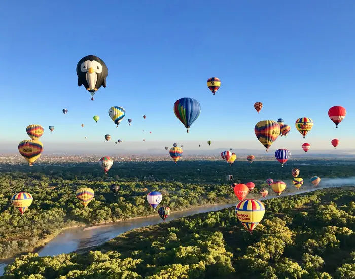Hot air balloons of different designs and colors floating in Albuquerque, New Mexico.