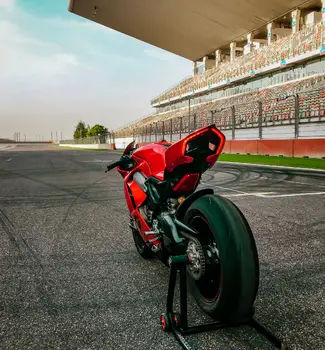 Red bike on the Charlotte Motor Speedway in North Carolina on the track with empty benches on a sunny day.