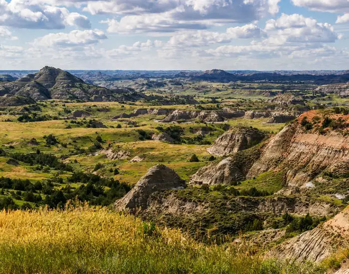 North Dakota Badlands with stone hills and mountains covered with natural greenery.