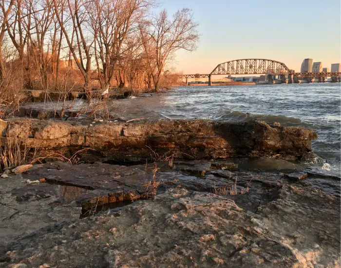 Falls of Ohio State Park in Louisville with rocky waves crashing into the coastline in autumn weather at dusk.