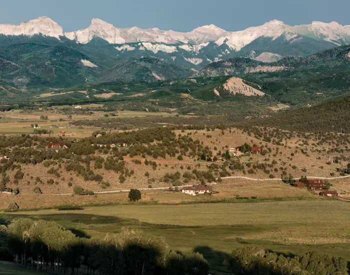 Cimarron Range close to Oklahoma aerial view of shadows from clouds, fields, mountains, and small villages.