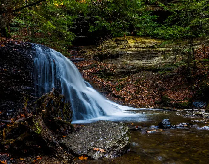 McConnell's Mill State park waterfall  flowing down rocks surrounded by nature in Pennsylvania during fall autumn weather.