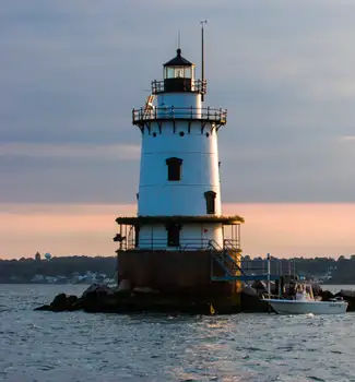 Save the Bay lighthouse tour at sunset in Newport, Rhode Island with a white lighthouse perched in the middle of a lake.
