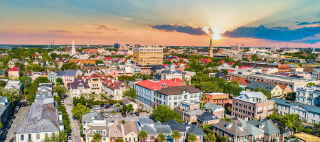 Downtown Charleston, South Carolina skyline aerial view overlooking city buildings during sunrise.
