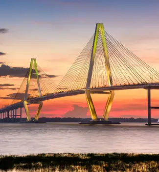 Arthur Ravenal Jr. Bridge also known as Bridge of Charleston in South Carolina at sunset stretching across water.