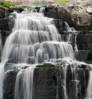 Long exposure of water running down rocky steps like a waterfall in Falls Park in Sioux Falls, South Dakota.