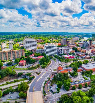 Knoxville, Tennessee aerial view of the city with raised overhead highways, buildings, and partly cloudy sky.