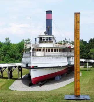 Large cruise ship model perched on gravel and grass in the Shelbourne Museum in Vermont.