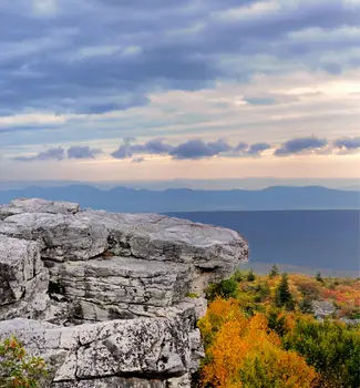 View from Bear Rock in West Virginia on a cloudy day with rocks, trees, and warm toned leaves in autumn.