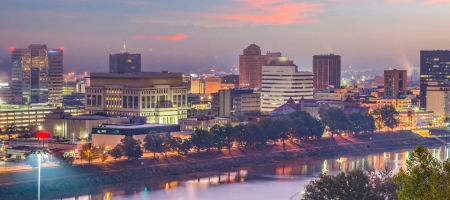 Charleston, West Virginia skyline at dusk beside a river with warm dreamy tones.