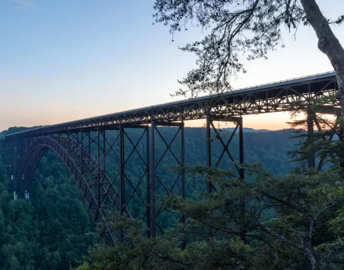 Longest bridge in Victor, Virginia stretching over the New River Gorge at dusk over thick nature forestry.